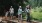 a group of people standing on a log in a forest